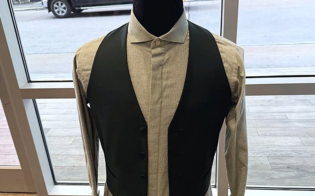 A tan shirt under a black waistcoat on the shop's dress form