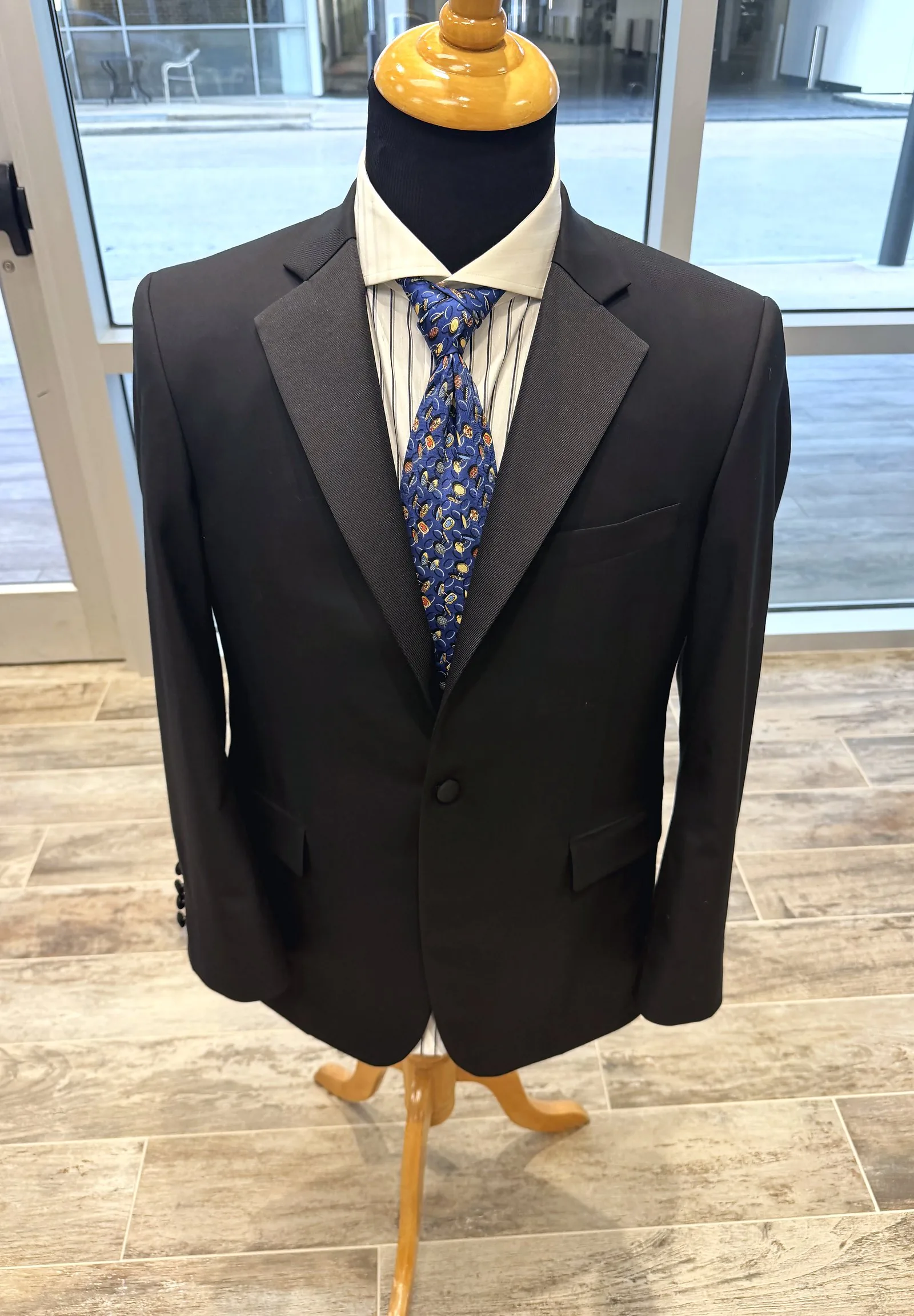 The same black dinner jacket, finished and pressed, on the shop's form
