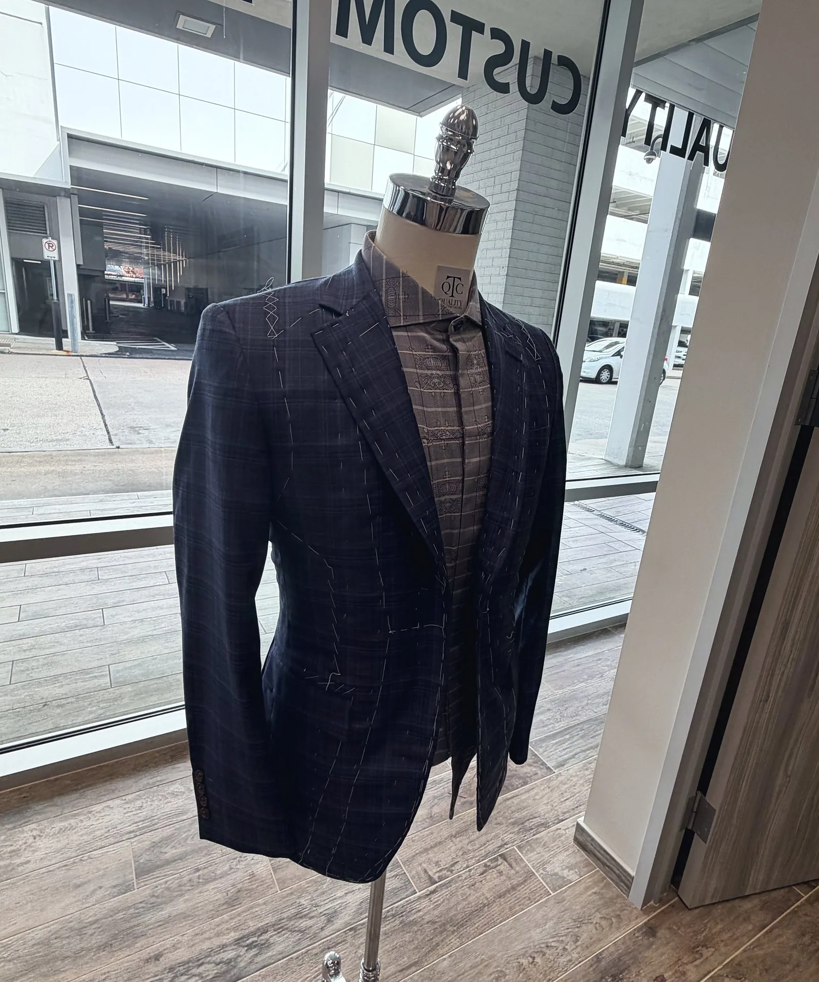 A basted plaid jacket on the form at the shop's front window